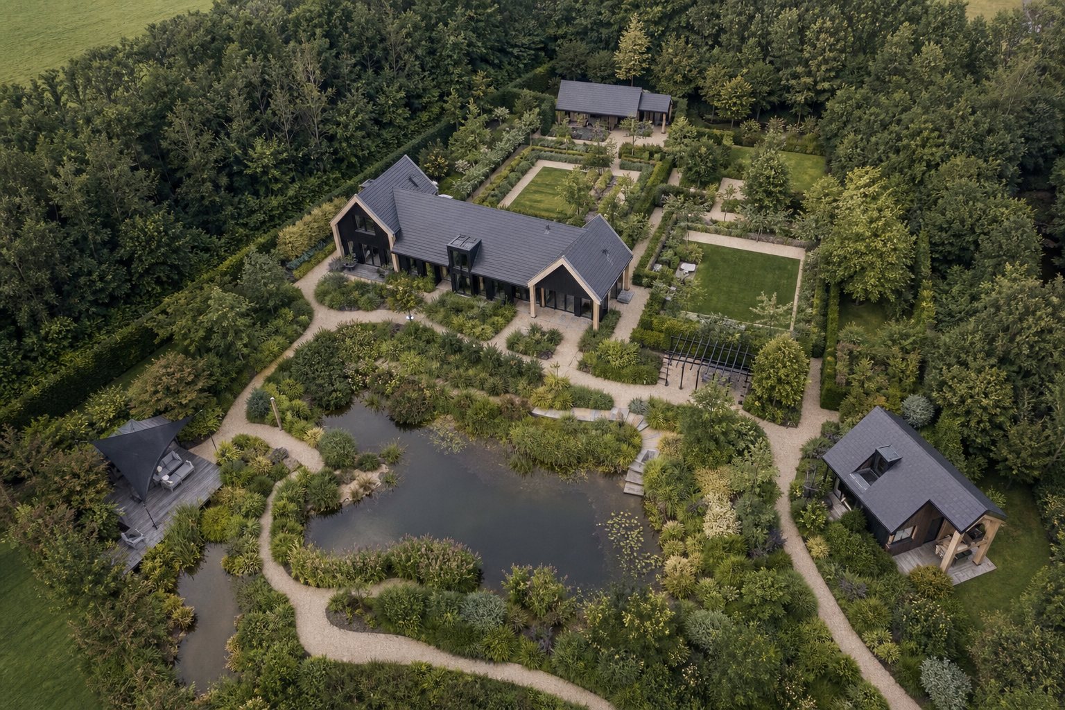 Sfeerimpressie vanuit de lucht van een landgoed met woning, vijver en landschap.