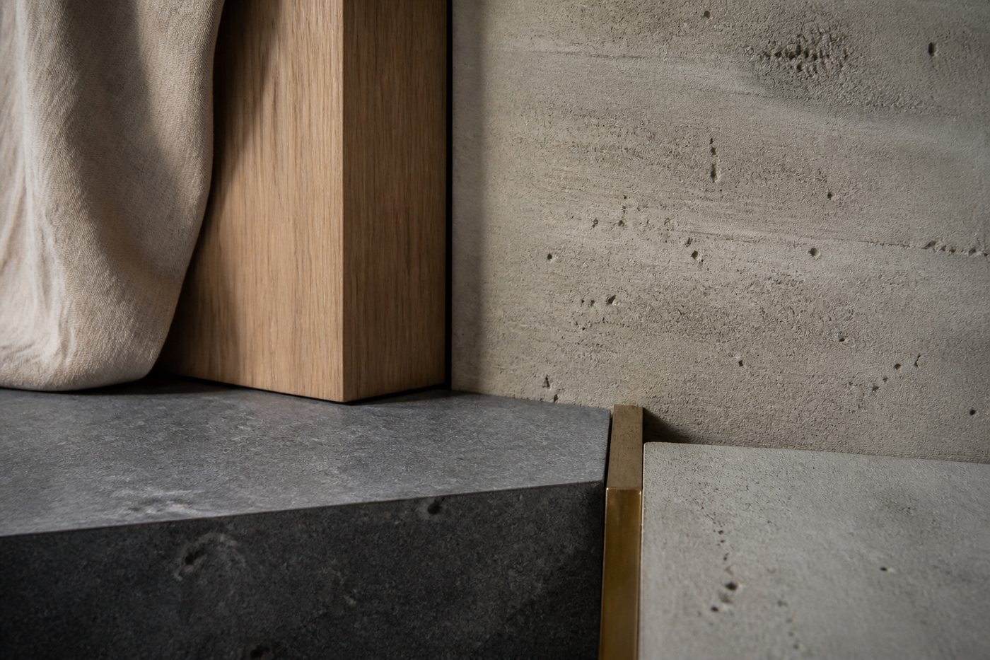 Sfeerimpressie van materialen: eiken, beton, natuursteen en een fijn metalen detail.